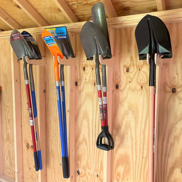 A neatly organized shed with a shelf holding tools and other items. Utilize shed organizer kit, shelf brackets, and yard tool hooks for efficient storage.
