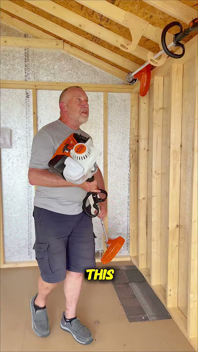 Man placing weed whacker in organization devices.
