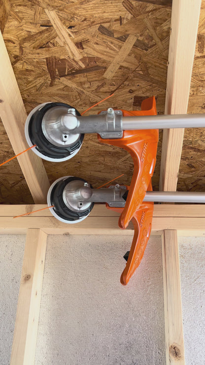 Weed whackers mounted on ceiling in shed.