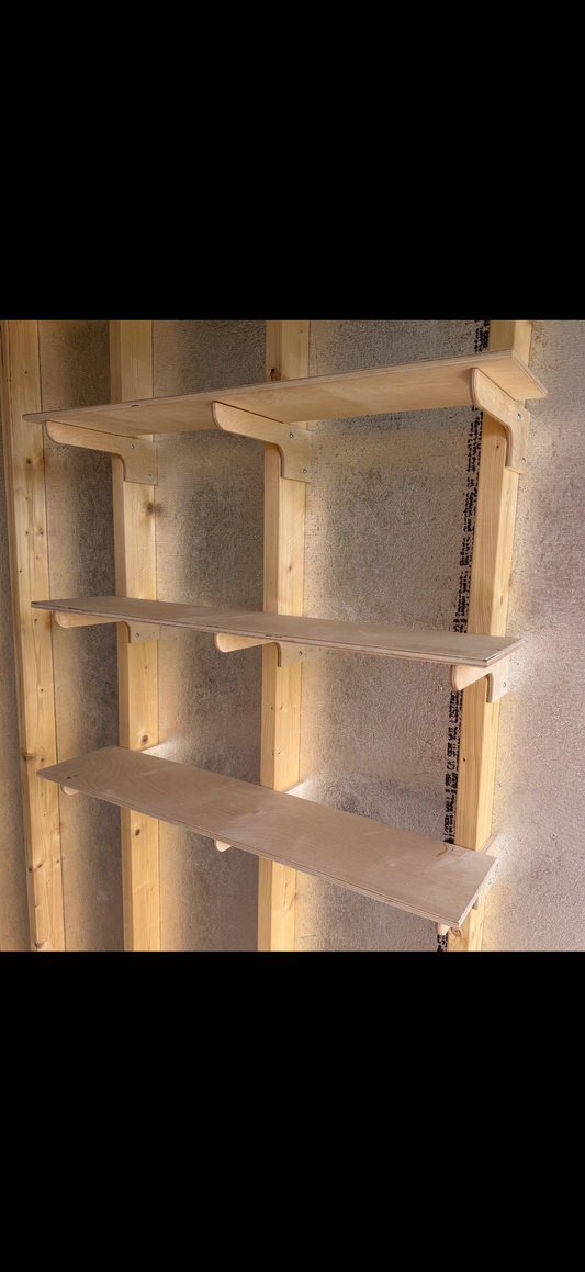 Installing wood shelves on brackets in a shed.