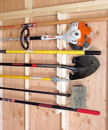Shed tool rack storing rakes, shovels, a string trimmer, and other long-handled tools neatly for efficient and space-saving organization.