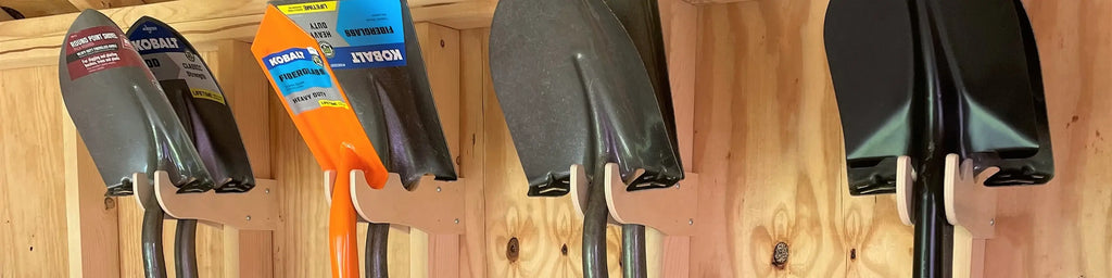 Wall-mounted shed tool rack holding shovels and garden tools for organized, space-saving storage.