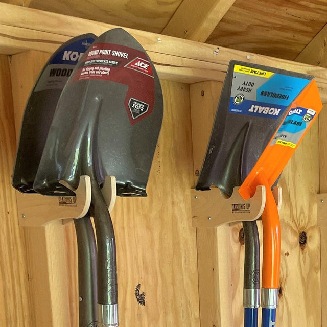 Shed tool storage rack holding shovels securely, keeping garden tools organized and easily accessible in a wooden shed.