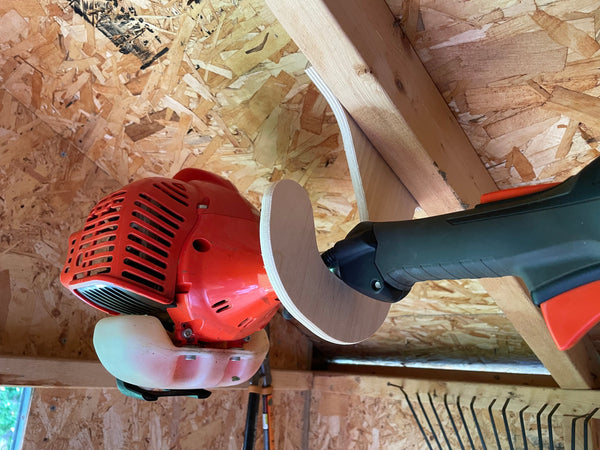 Ceiling mounted Weed Wacker rack in a storage shed.