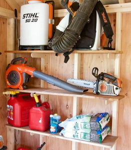 Shelving brackets with multiple tools and outdoor equipment on them 