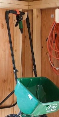 Lawn spreader hanging from a miscellaneous shed organizer 