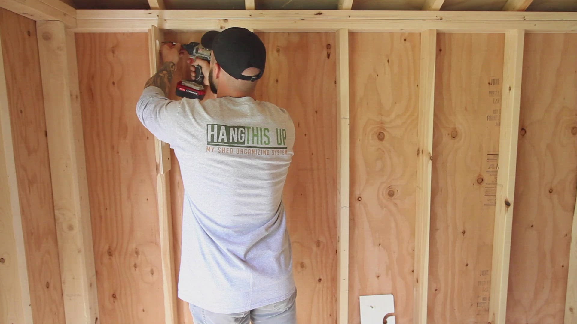 A wooden fishing rod rack hanging from the ceiling, providing storage for fishing rods in a garage space.  Video install.